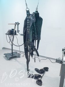 leather strait jacket suspended from the Laboratory ceiling