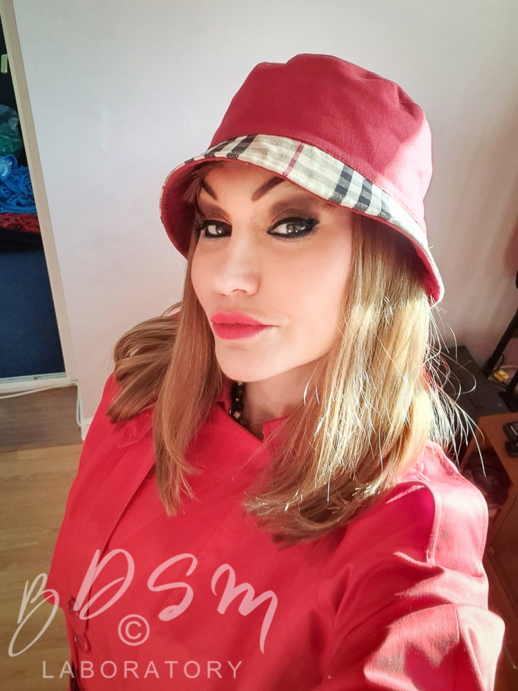 Mistress Miranda wearing red Mackintosh coat and hat
