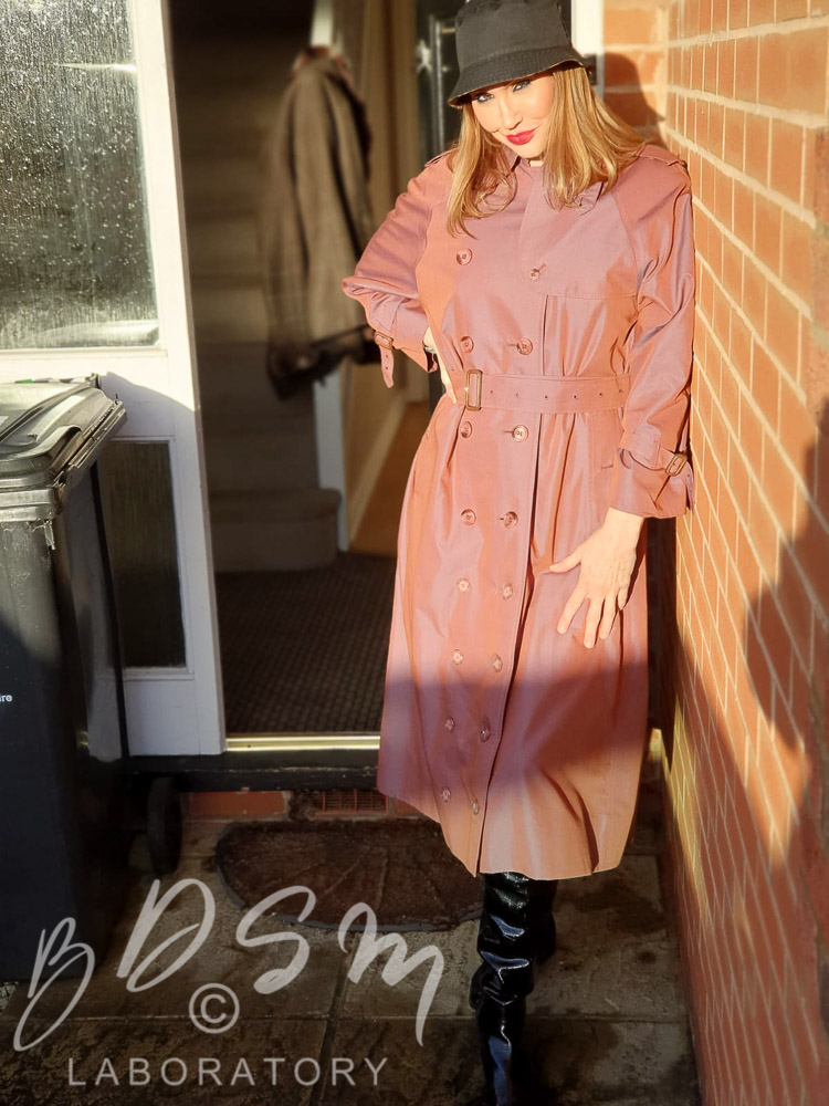 Mistress Miranda wearing a red Mackintosh and hat